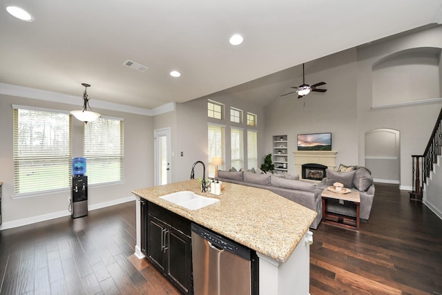 kitchen with pendant lighting, a kitchen island with sink, dishwasher, and sink