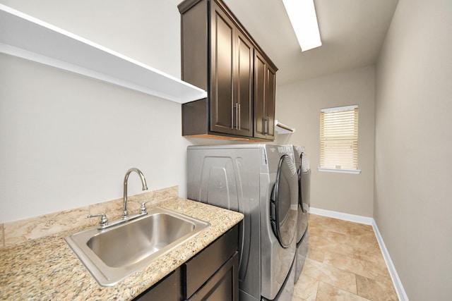 washroom with washer and dryer, sink, and cabinets