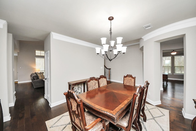 dining area with a notable chandelier, dark wood-type flooring, and ornamental molding