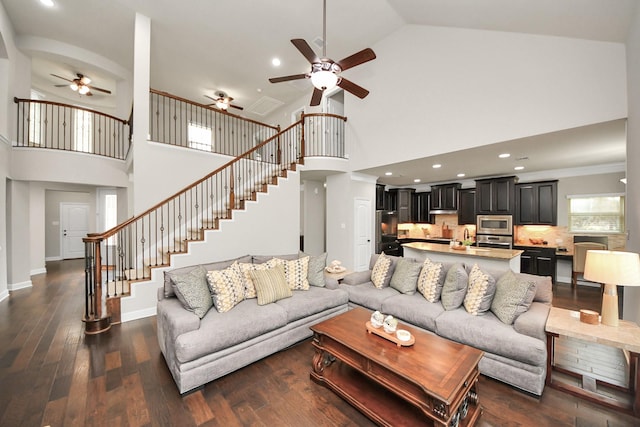 living room featuring ceiling fan, dark hardwood / wood-style floors, and high vaulted ceiling