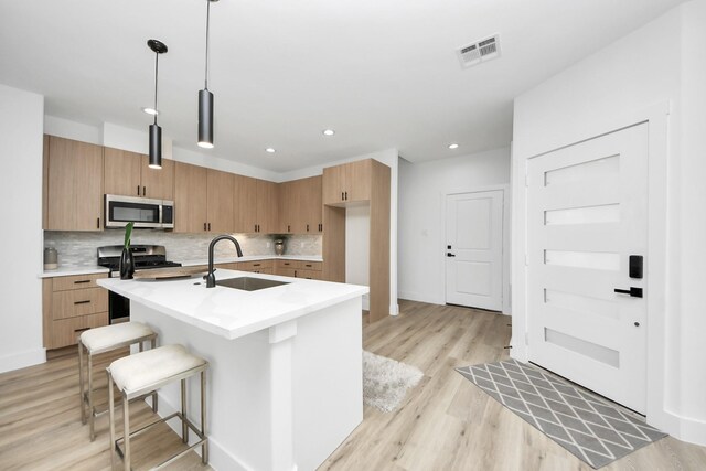 9026 Scott St, Houston, TX 77051 - kitchen with tasteful backsplash, visible vents, appliances with stainless steel finishes, light countertops, and a sink