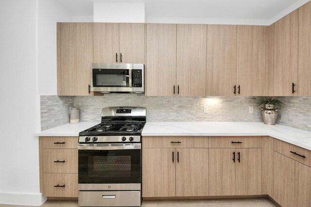 9026 Scott St, Houston, TX 77051 - kitchen featuring backsplash, light stone counters, light brown cabinets, and stainless steel appliances