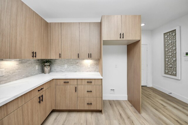 9026 Scott St, Houston, TX 77051 - kitchen with baseboards, light wood finished floors, decorative backsplash, and light brown cabinetry