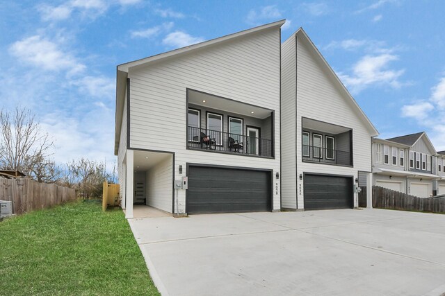 9026 Scott St, Houston, TX 77051 - view of side of property with a lawn, fence, a balcony, an attached garage, and concrete driveway