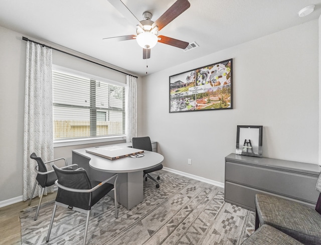 office featuring visible vents, ceiling fan, light wood-style flooring, and baseboards