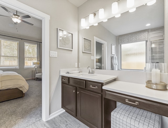 bathroom with a ceiling fan, ensuite bath, vanity, and baseboards