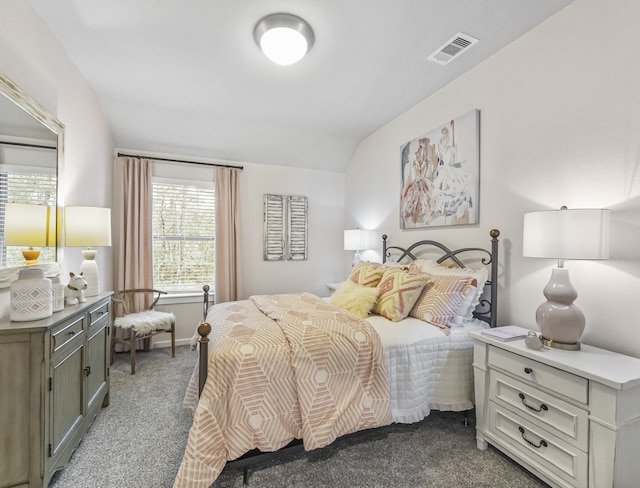 carpeted bedroom with visible vents and vaulted ceiling