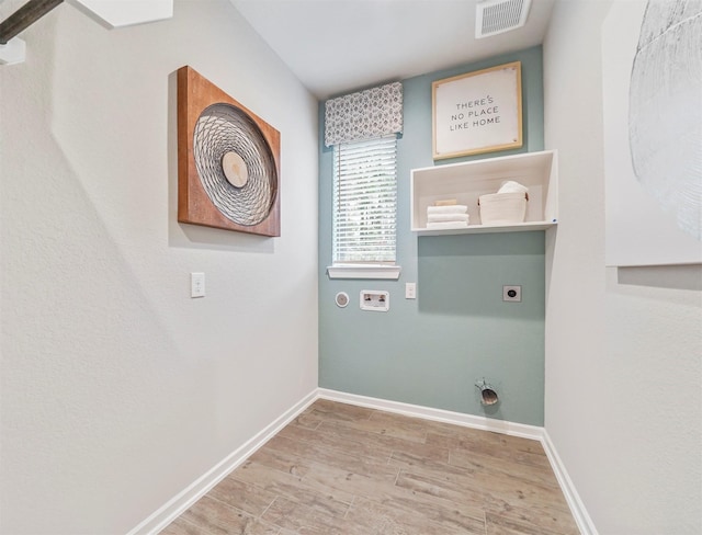 laundry area with visible vents, light wood-type flooring, electric dryer hookup, and baseboards