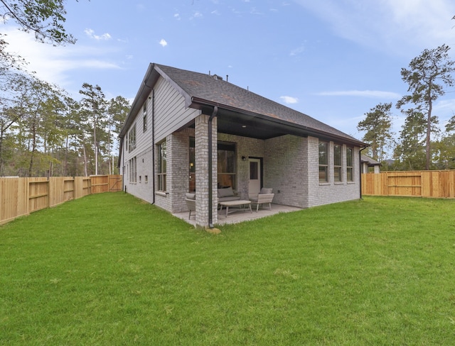 rear view of property featuring a patio area, brick siding, a fenced backyard, and a lawn