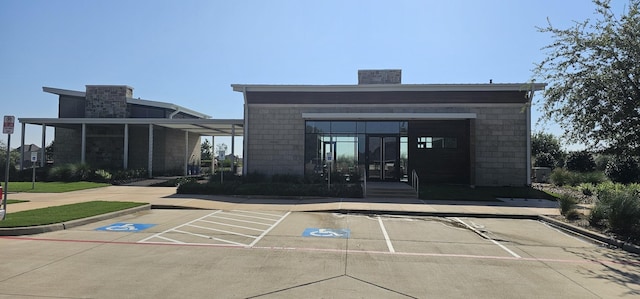 view of exterior entry featuring a chimney and concrete block siding