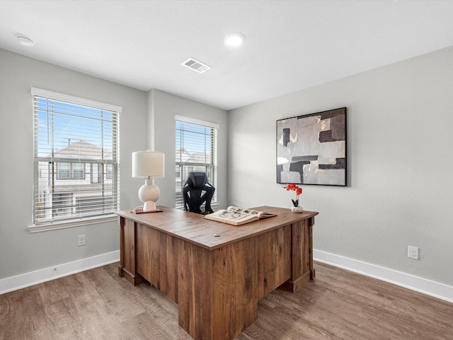 office with a wealth of natural light and hardwood / wood-style floors