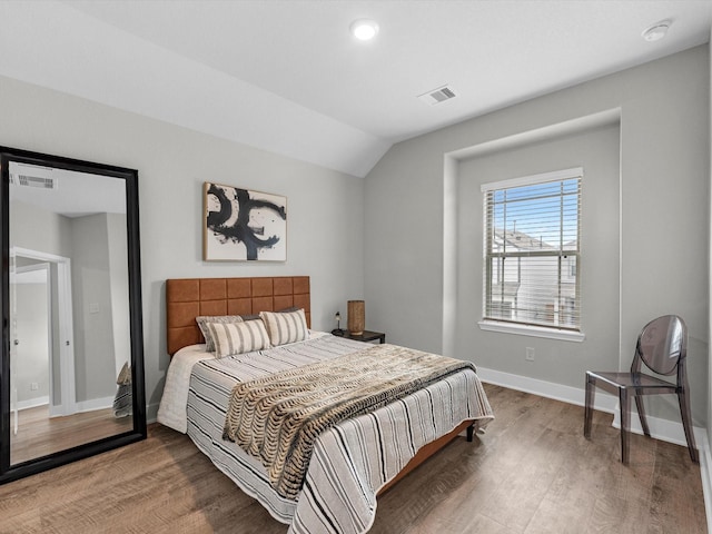 bedroom with lofted ceiling and wood-type flooring