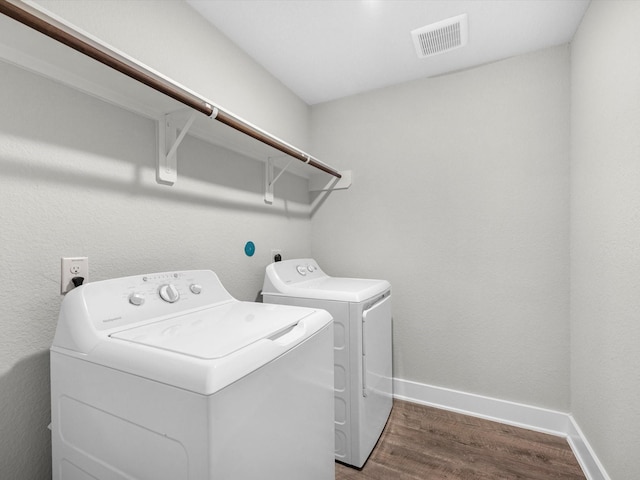 washroom with dark hardwood / wood-style floors and washer and clothes dryer