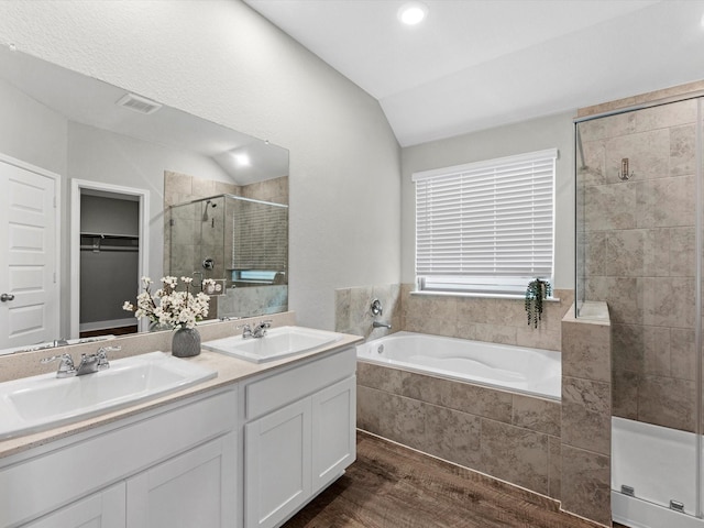 bathroom featuring lofted ceiling, vanity, and independent shower and bath