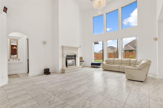 18111 Dockside Landing Dr, Cypress, TX 77433 - living room featuring a towering ceiling, light marble finish floors, arched walkways, a glass covered fireplace, and a chandelier