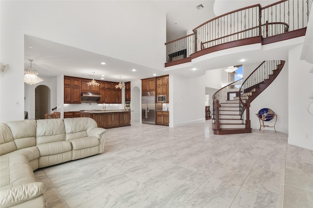 18111 Dockside Landing Dr, Cypress, TX 77433 - living area with arched walkways, a chandelier, light marble finish floors, stairway, and a high ceiling