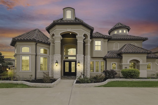 18111 Dockside Landing Dr, Cypress, TX 77433 - exterior entry at dusk featuring french doors, a tile roof, and stucco siding