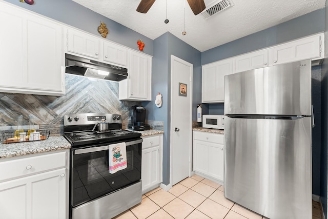 kitchen featuring white cabinetry, backsplash, light tile patterned floors, stainless steel appliances, and light stone countertops