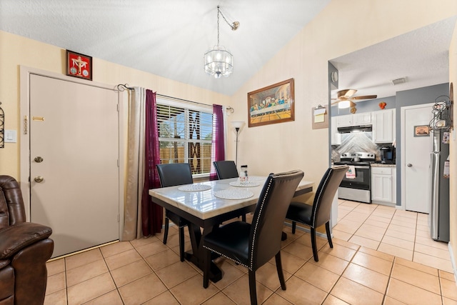 tiled dining space featuring lofted ceiling and ceiling fan with notable chandelier