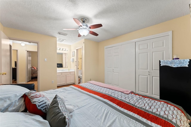 bedroom featuring a textured ceiling, a closet, ceiling fan, and ensuite bathroom