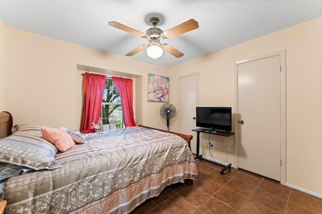 tiled bedroom featuring a textured ceiling and ceiling fan