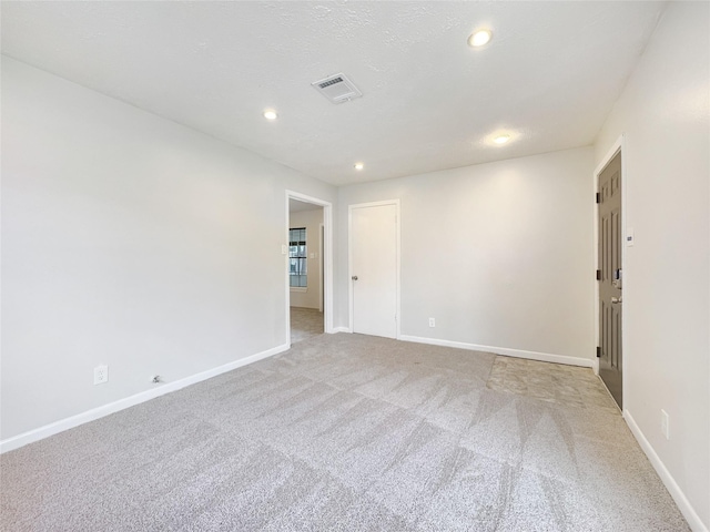 unfurnished room featuring light carpet, baseboards, and visible vents