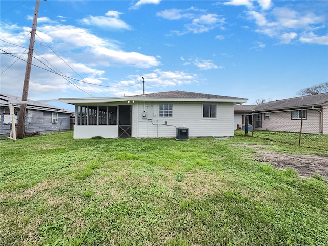 back of house featuring central AC unit, a lawn, and a sunroom