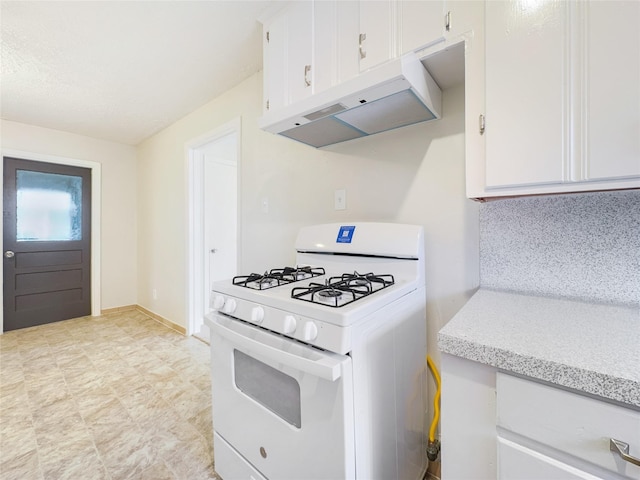 kitchen with white gas stove, light countertops, white cabinetry, and under cabinet range hood