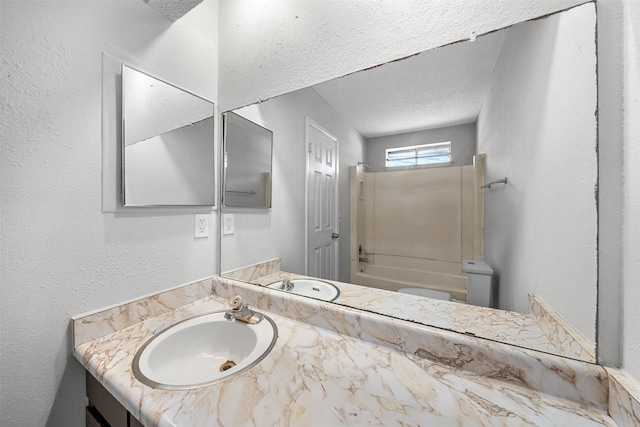 bathroom featuring tub / shower combination, a textured wall, vanity, and a textured ceiling