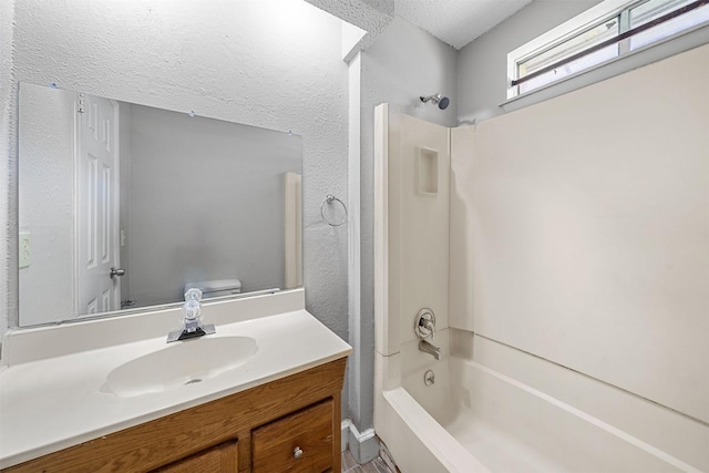 full bathroom with a textured wall, shower / bathing tub combination, vanity, and toilet