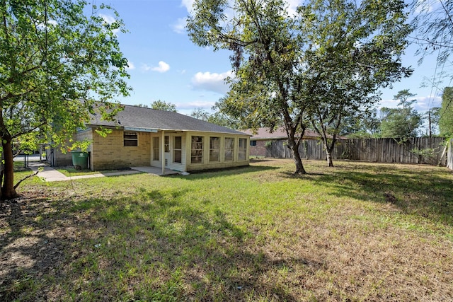 rear view of house with a patio area, a fenced backyard, a lawn, and brick siding