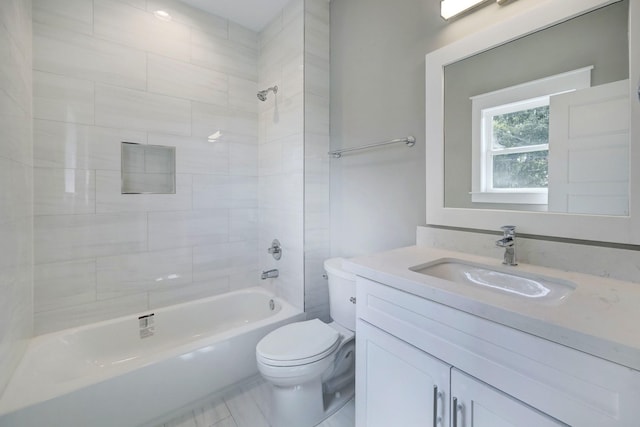 full bathroom featuring tiled shower / bath combo, vanity, and toilet