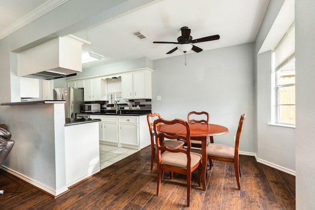 kitchen featuring stainless steel refrigerator, light wood-type flooring, white cabinetry, and backsplash