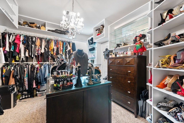 walk in closet featuring an inviting chandelier and light colored carpet