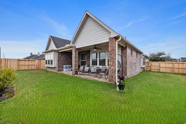 rear view of property featuring a yard, a patio area, and ceiling fan