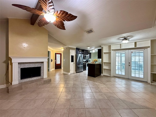 unfurnished living room with french doors, vaulted ceiling with beams, light tile patterned floors, built in features, and a fireplace