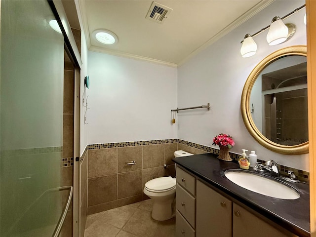 bathroom with toilet, tile walls, ornamental molding, vanity, and tile patterned flooring