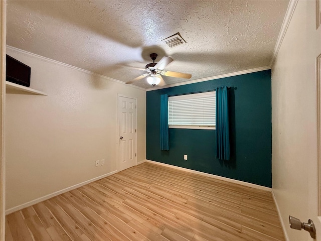 spare room featuring ceiling fan, ornamental molding, light hardwood / wood-style floors, and a textured ceiling