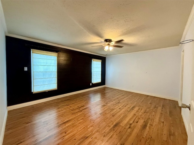 spare room with ceiling fan, wood-type flooring, ornamental molding, and a textured ceiling