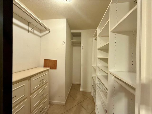 walk in closet with light tile patterned floors