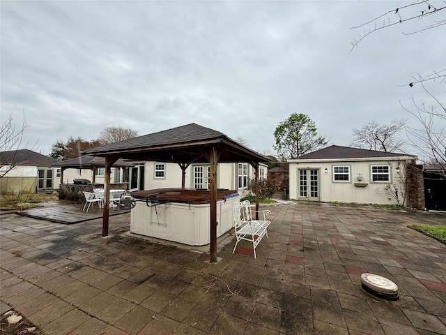 view of patio featuring a gazebo, an outdoor structure, a hot tub, and french doors