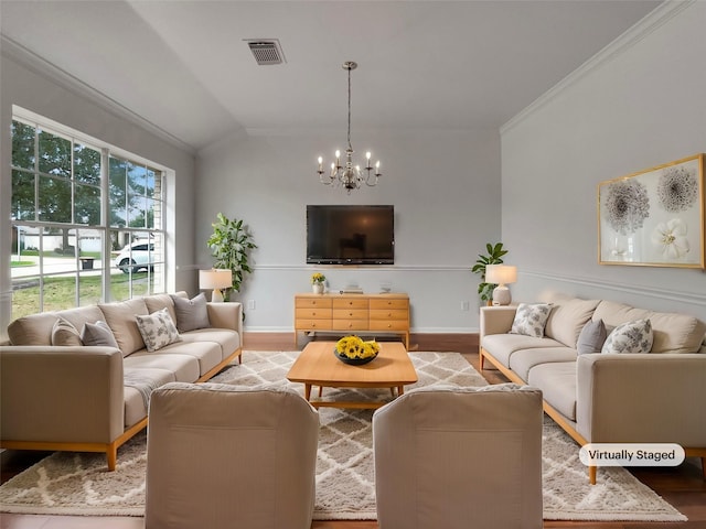 living room featuring lofted ceiling, visible vents, wood finished floors, and ornamental molding