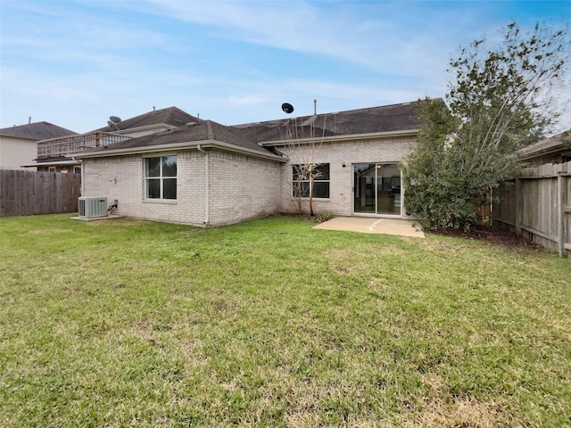 rear view of property with central AC unit, a fenced backyard, brick siding, a lawn, and a patio area