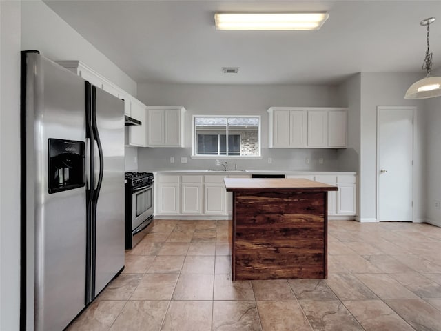 kitchen featuring white cabinetry, appliances with stainless steel finishes, light countertops, and decorative light fixtures