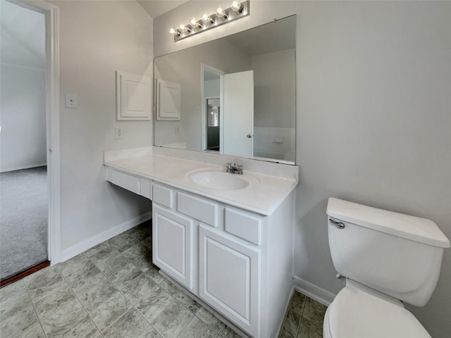 bathroom with vanity, toilet, and baseboards