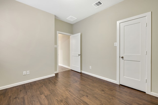 unfurnished bedroom featuring baseboards, visible vents, and dark wood finished floors