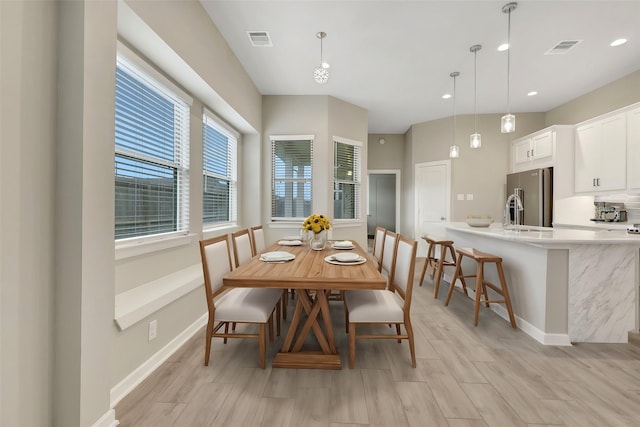 dining area with wood finish floors, visible vents, and baseboards