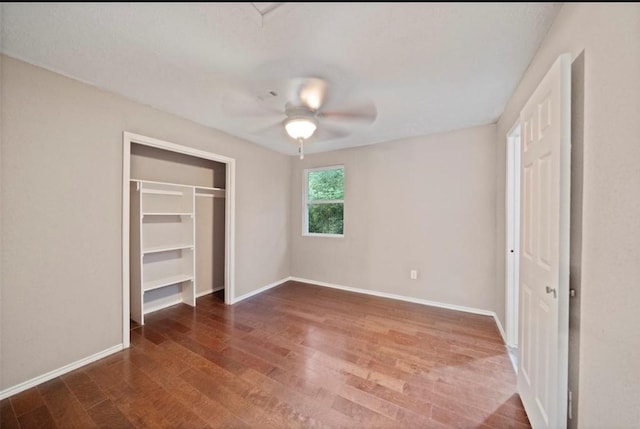 unfurnished bedroom featuring ceiling fan, dark hardwood / wood-style flooring, and a closet