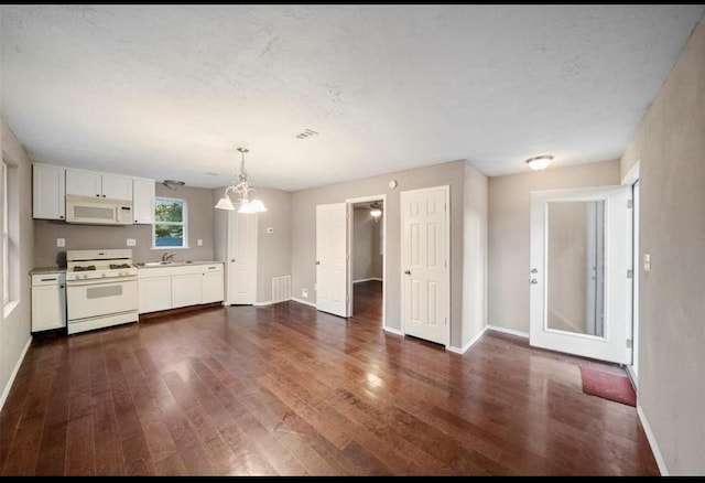 kitchen with dark wood-type flooring, sink, pendant lighting, white appliances, and white cabinets