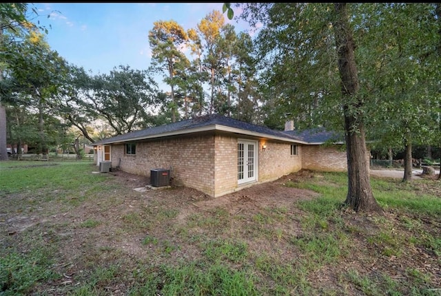 view of home's exterior with french doors and central air condition unit